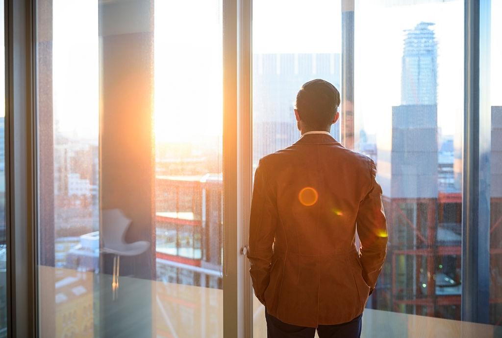 A man standing in front of window wall
