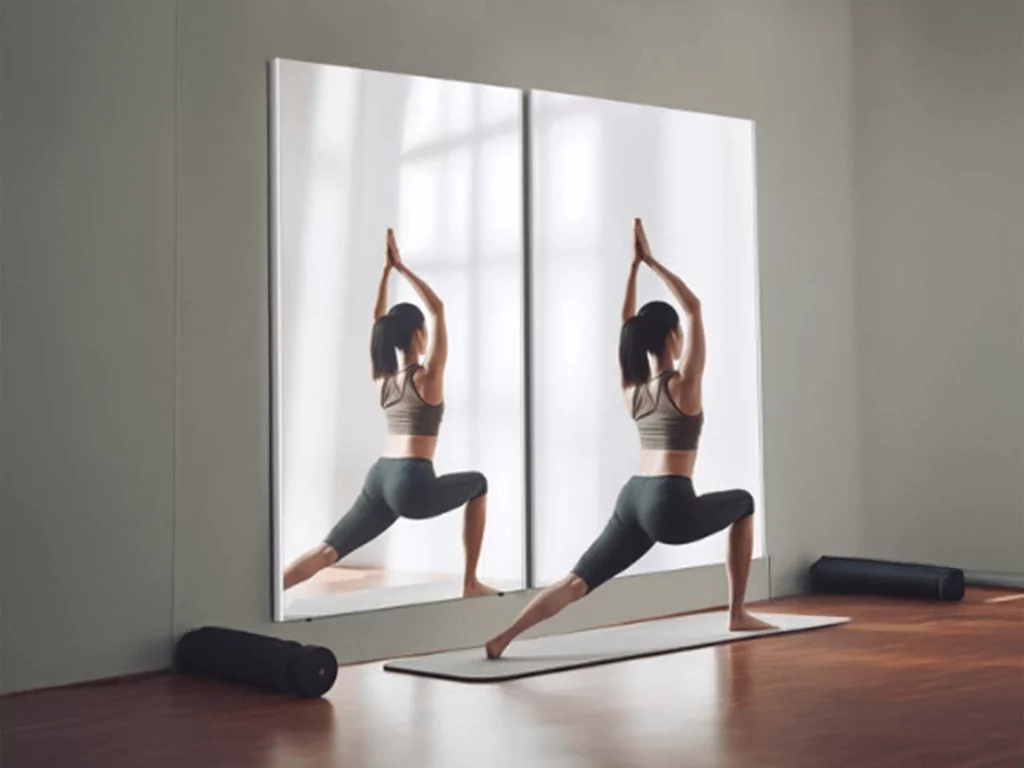 A woman practicing yoga in front of two large wall-mounted glassless mirrors.