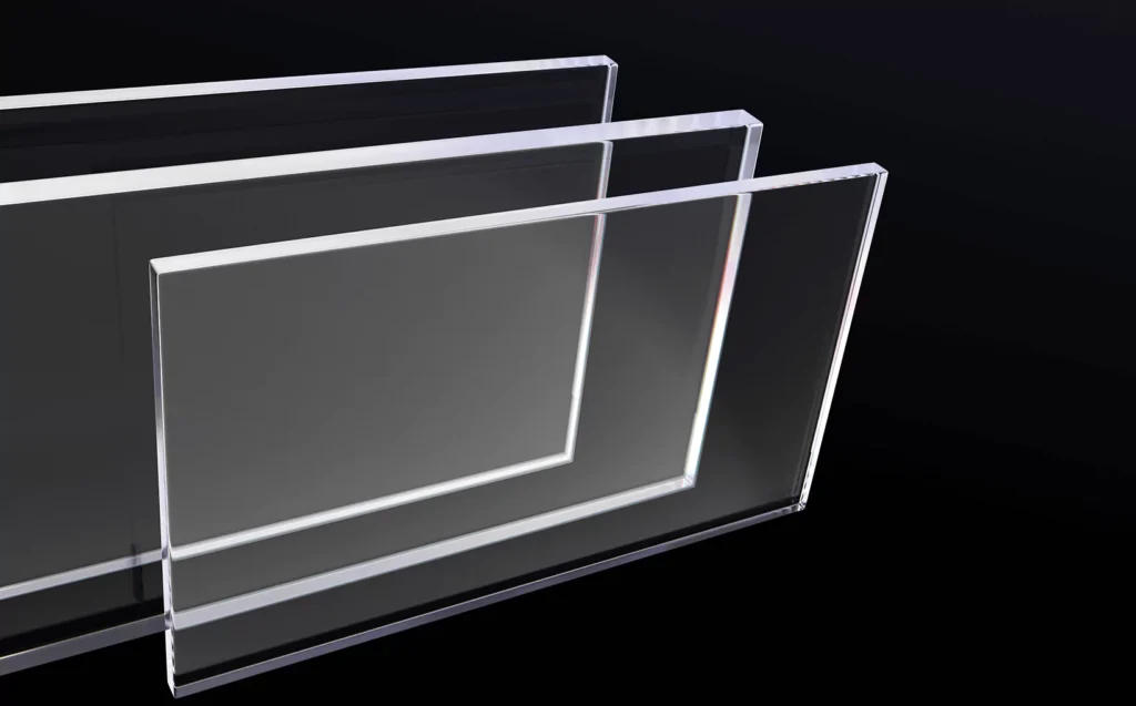Stacked clear plexiglass sheets shown against a dark background, highlighting thickness and clarity.