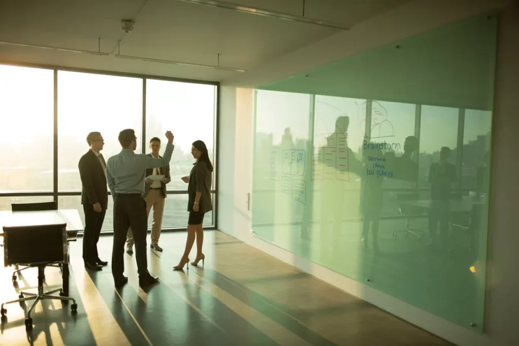 Modern office with a large tempered glass whiteboard, showing a clean, stain-free surface for team collaboration.