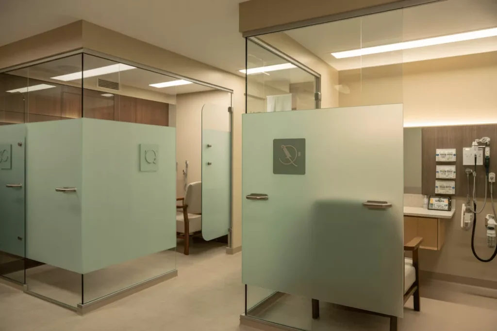 ADA-compliant frosted and satin-etched glass partitions in a senior-care facility with rounded edges and safety hardware.
