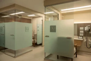 ADA-compliant frosted and satin-etched glass partitions in a senior-care facility with rounded edges and safety hardware.