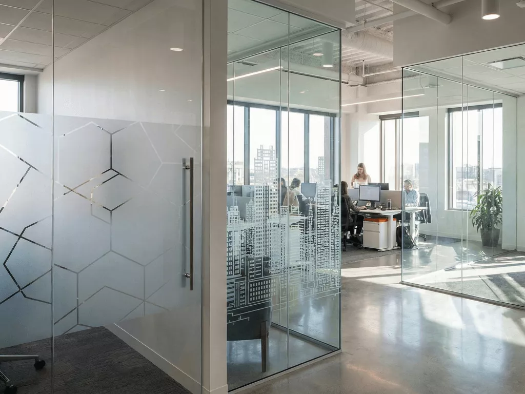 Office glass partitions with frosted films, ceramic frit etching, and low-iron clear panels, realistic workspace lighting.