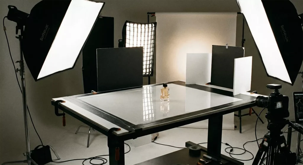 Product photography setup with acrylic/glass, softboxes, backlight, reflection control, and centered luxury product.