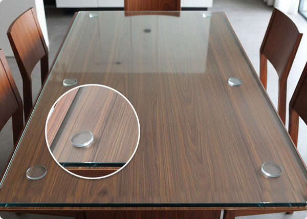 Assorted clear glass table top bumpers and pads for protecting furniture surfaces.