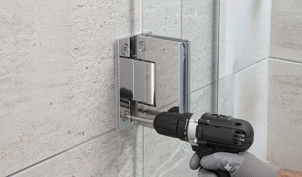 Professional installation of shower door hinge replacement using power drill