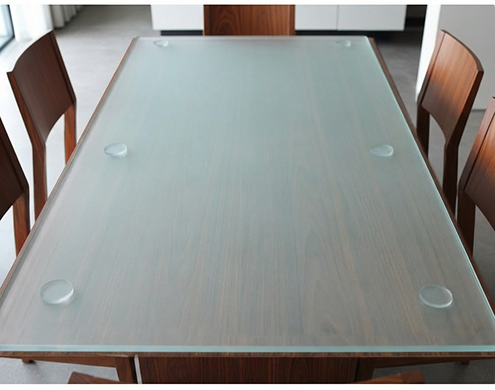 Elegant frosted glass dining table with wooden chairs