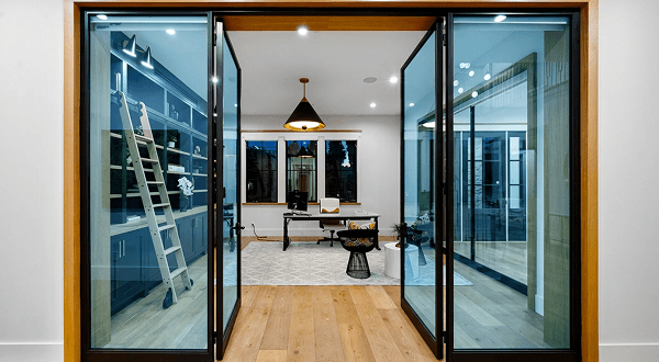 Modern home interior with sliding blue tempered glass doors leading to a stylish home office.