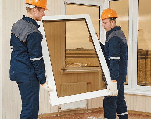 Experts installing a bronze tinted tempered glass window, showcasing custom cut precision and professional quality. 