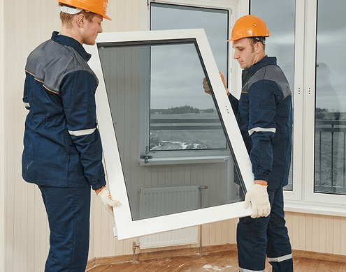 Workers installing window with ECL tinted grey glass cut to size in a workshop.