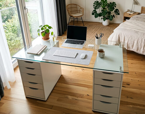 Glass table top for Alex desk with laptop and plants in sunny minimalist workspace