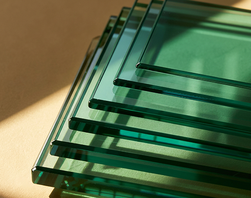 Thick green tempered glass panels stacked in various thicknesses and sizes
