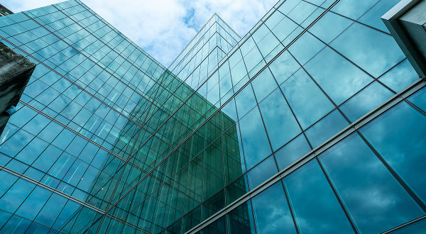 Striking blue-green facade of high-rise building with light green tempered glass