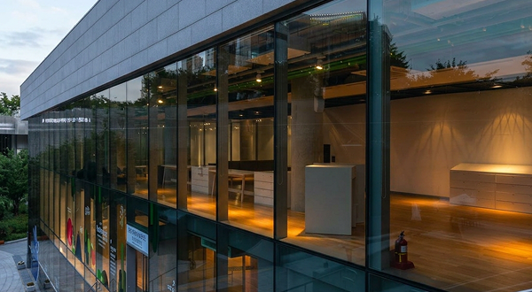 Elegant commercial building with expansive graylite ii glass facade and warm interior lighting