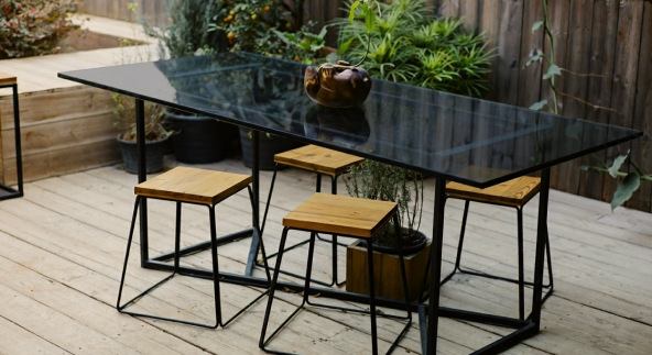 Outdoor patio table with super grey tempered glass top and wooden stools