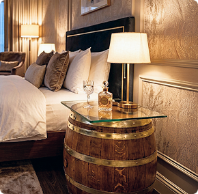 Wine barrel glass top bedside table with lamp in a cozy modern bedroom